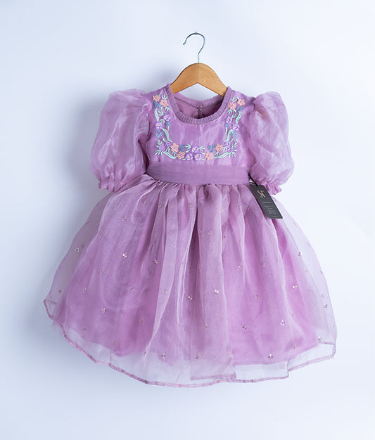 A pastel lavender floral embroidery party frock on a hanger.