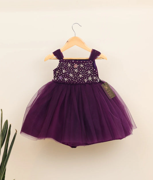 Front view of a violet tulle net hand-worked birthday frock for baby girl