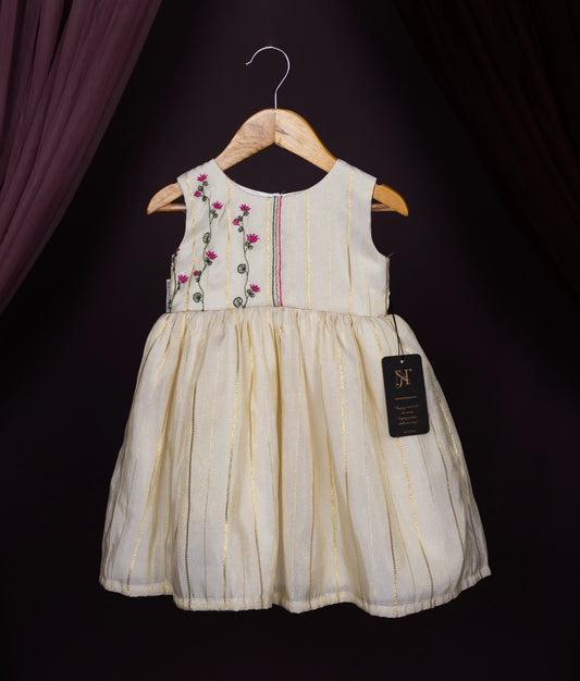 An offwhite floral embroidery frock for kids displayed on a hanger, featuring a round neckline, sleeveless design, and a flared skirt.