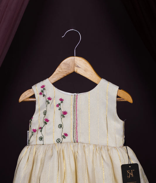 Traditional cream gold striped sleeveless baby frock with pink floral embroidery—festive wear by Nakshatra Kids.