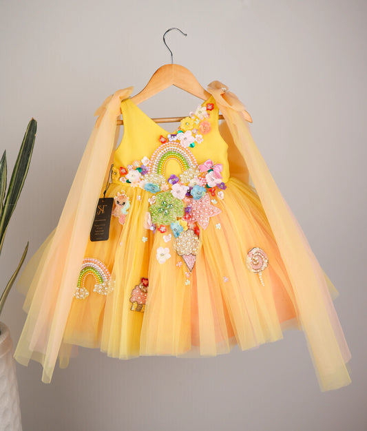 front view of yellow tulle net Handworked Multi-Theme Birthday Frock against plain background