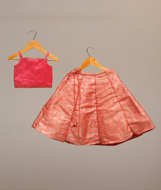Kids' hot-pink lehenga choli set with a handwork-embellished top and a floral banarasi skirt.