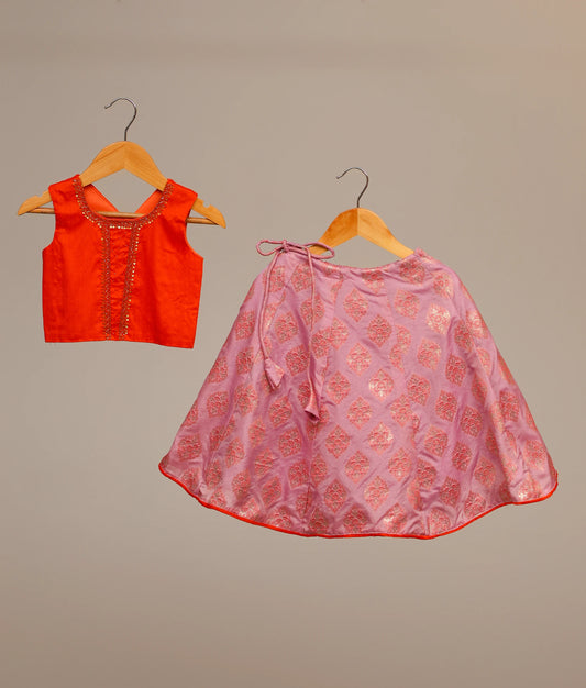 Orange raw cotta embellished crop top and a lilac banarasi printed skirt, a traditional Indian lehenga choli for kids.