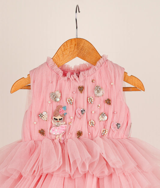 Close view of pink fairy-themed step birthday dress against plain background