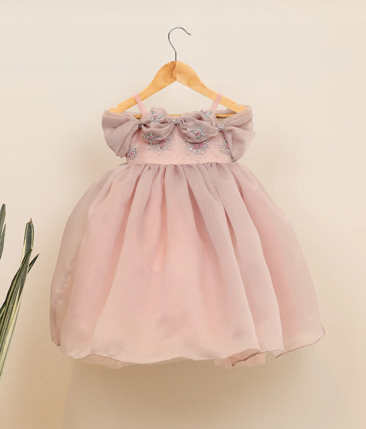 Front view of pastel pink plain organza handworked birthday gown against plain background