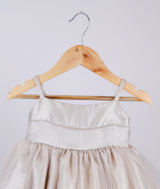 Close view of golden milan foil birthday frock for baby girl against white background