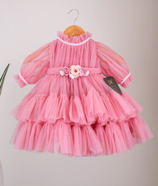 Front View of an onion-pink tulle net birthday frock hanging on white background.