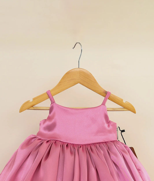 Close view of an rafaella pink cute birthday frock against plain background