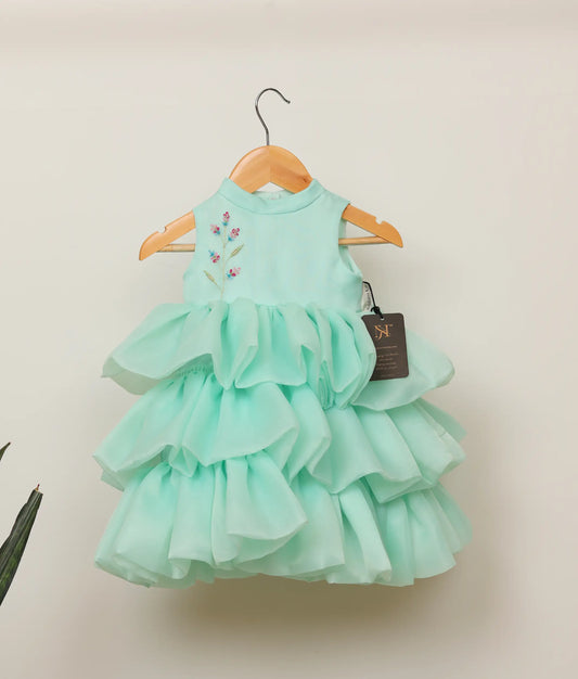 Front view of an plain organza floral handworked step birthday dress against plain background