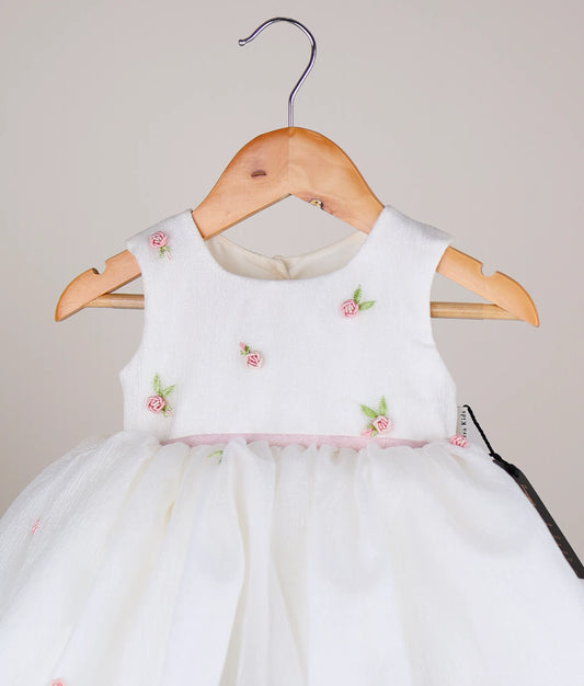 Close view of an off-white crush organza flower-themed dress against white background