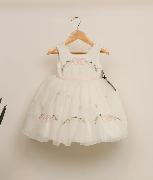 Front view of crush organza floral handwork birthday dress against plain background