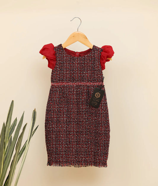 Front view of black handworked tweed handworked fish-cut frock against plain background