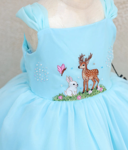 Close view of plain organza deer- and rabbit-themed birthday gown