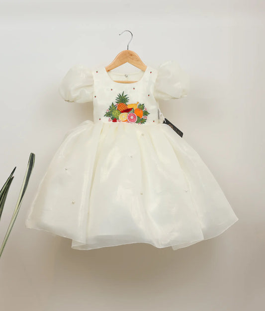 Front view of off-white plain organza tropical fruits-themed birthday dress against plain background