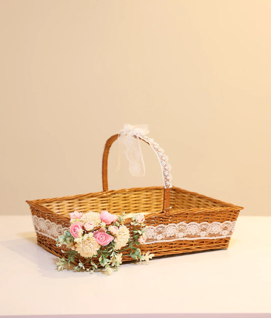 Off-white and pink wicker flower baptism basket for baby christening, against white background