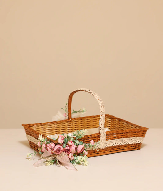 Pink flower and lace wicker basket for baby christening ,against plain background