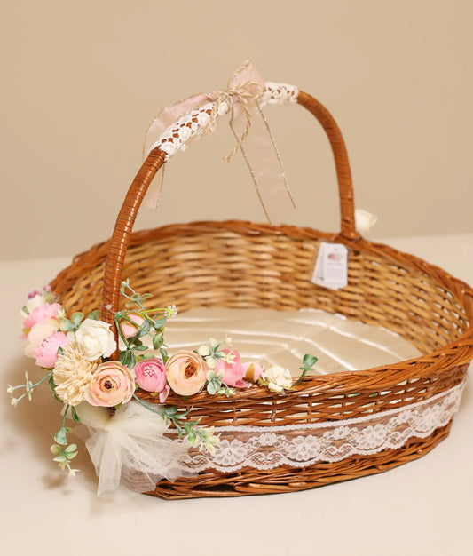 Close view of an off-white, pink, and peach flower baptism wicker basket in plain background