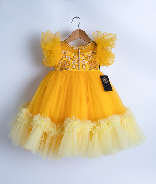 A yellow tulle net frock displayed on a hanger.