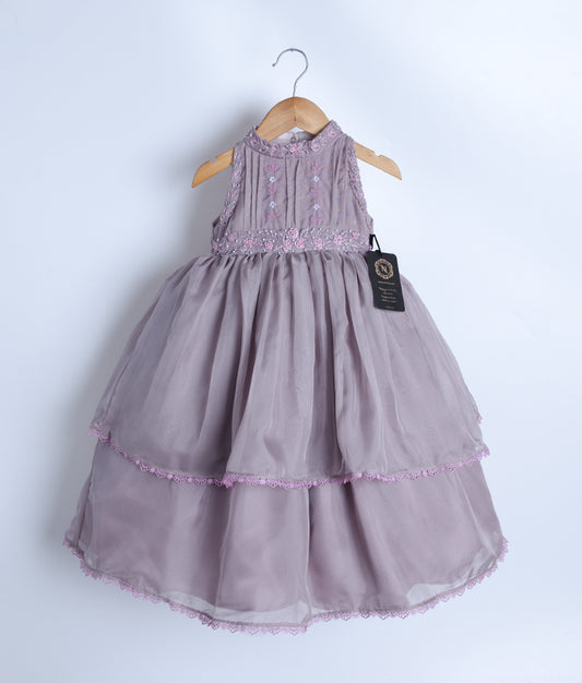 A pastel lavender tulle net casual frock with handworked beads and thread work, displayed on a hanger.