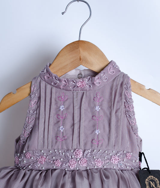 Close view of an pastel lavender tulle net casual frock displayed on a hanger.