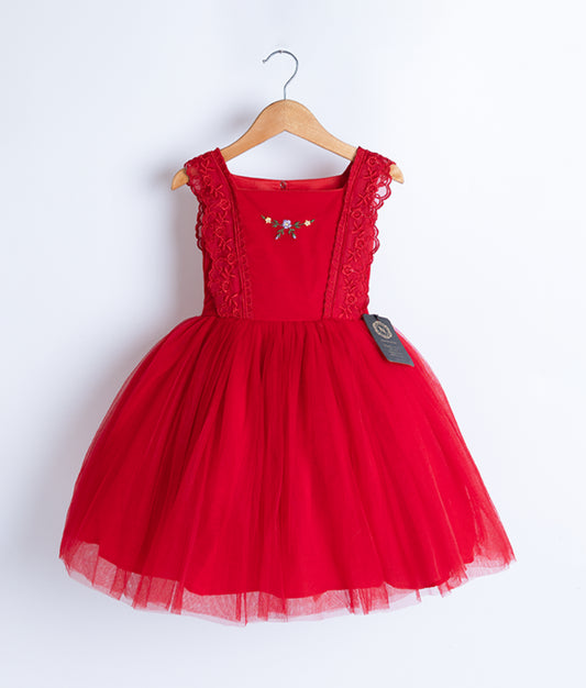 A red tulle net christmas frock displayed on a hanger.