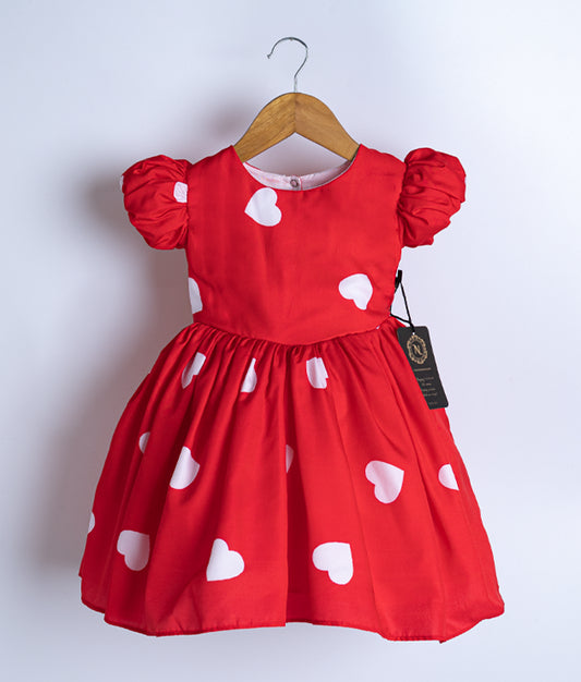 A red chiffon frock displayed on a hanger.