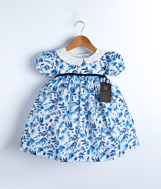 White and blue printed cotton frock displayed on a hanger.