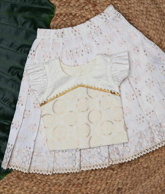 White lace skirt and top on a leaf and a woven mat background.