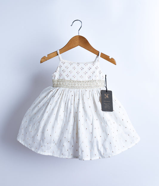 An off-white, sleeveless, flared frock with a band at the waist, displayed on a wooden hanger against a white background.