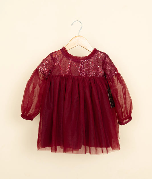 Red dress with lace details on a hanger against a beige background