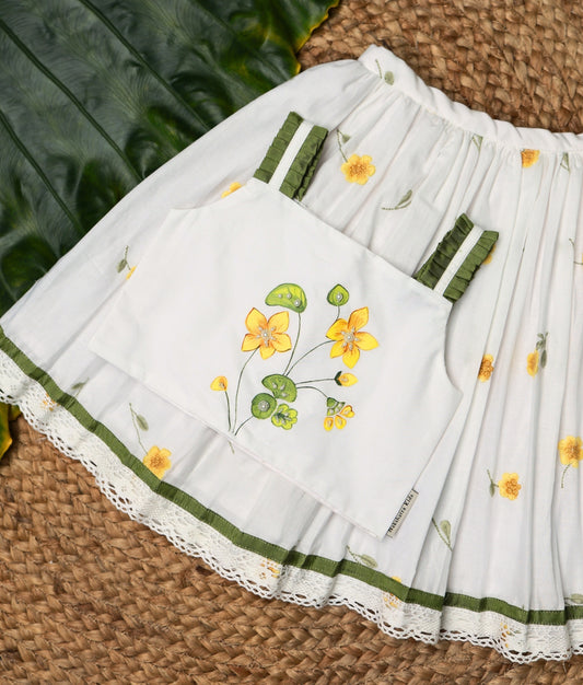 Close view of a white ethnic outfit with yellow floral prints and lace detailing, perfect for festive wear.