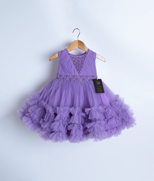 A sleeveless lavender party frock displayed on a wooden hanger.