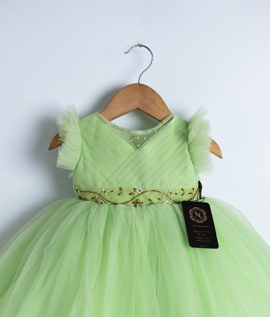 Close view of an pastel green tulle net frock displayed on a hanger.