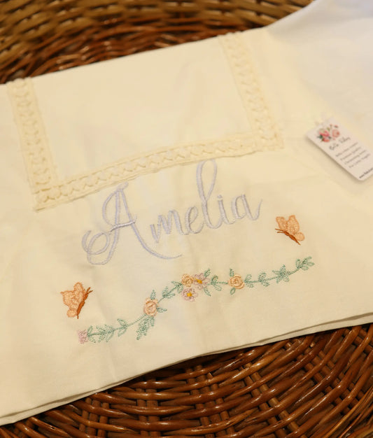 Close view of an off-white embroidery baptism towel with a customized name.