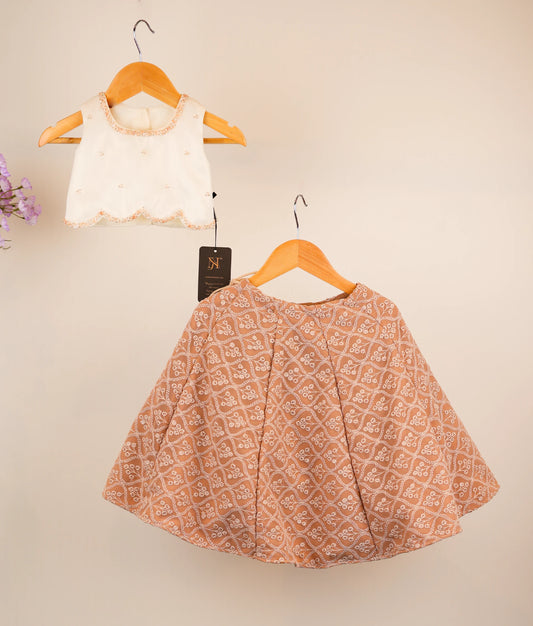 Off-white top and georgette skirt on hangers against a beige background