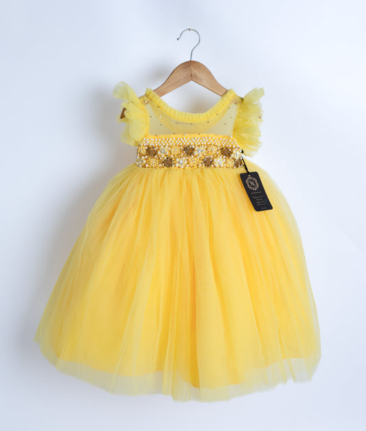 A yellow tulle net frock displayed on the hanger.