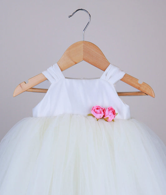 Close view of an off-white tulle net birthday frock against a white background.