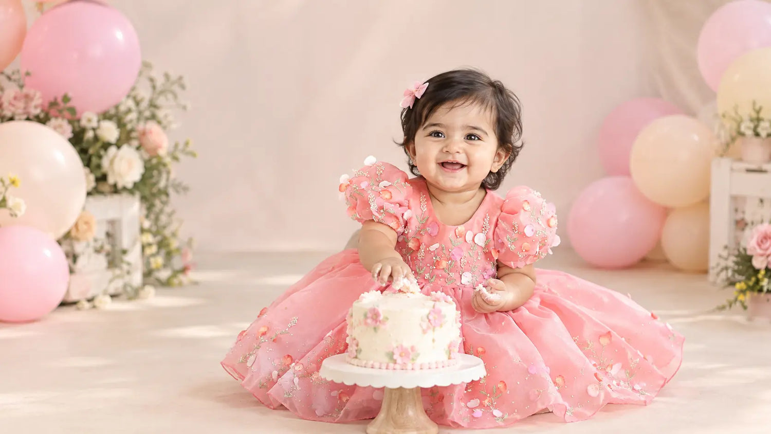 Baby girl in a pink floral cake smash dress by Nakshatra Kids