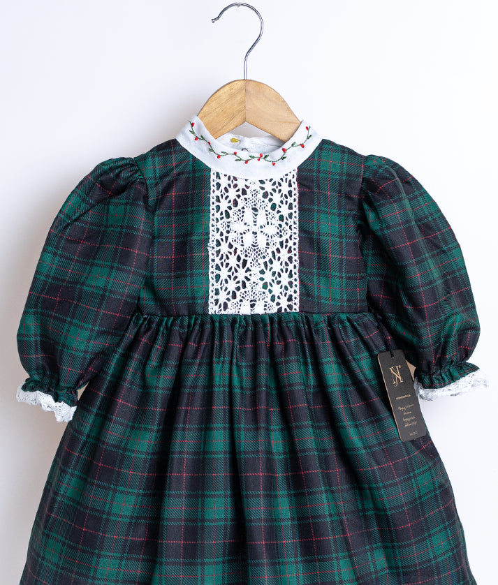 Close view of an black and green checkered cotton frock displayed on a hanger.