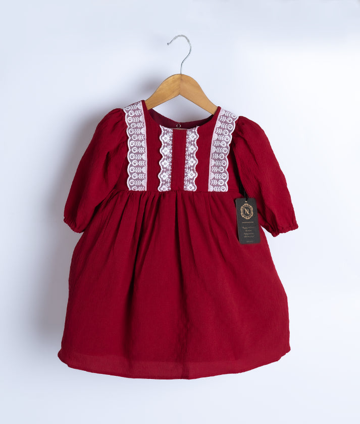 A maroon georgette christmas frock displayed on a hanger.