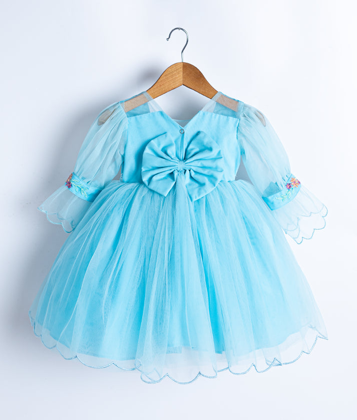 A light blue baby girl frock with puff sleeves, a large front bow, and floral embroidery, displayed on a wooden hanger against a white background.