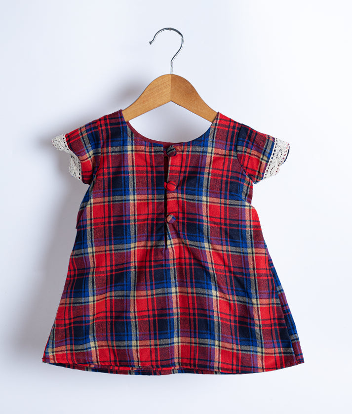 Back view of an red and white checkered cotton frock displayed on a hanger.