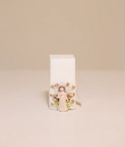 Elegant baptism candle with angel theme, featuring white lace, ribbon ruffles, and gold pearl accents