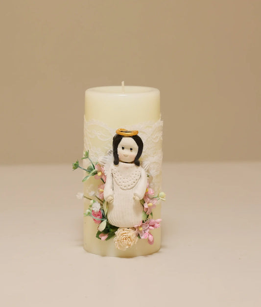 White decorative baptism candle featuring a miniature angel figurine, silk flowers, and delicate lace ruffles