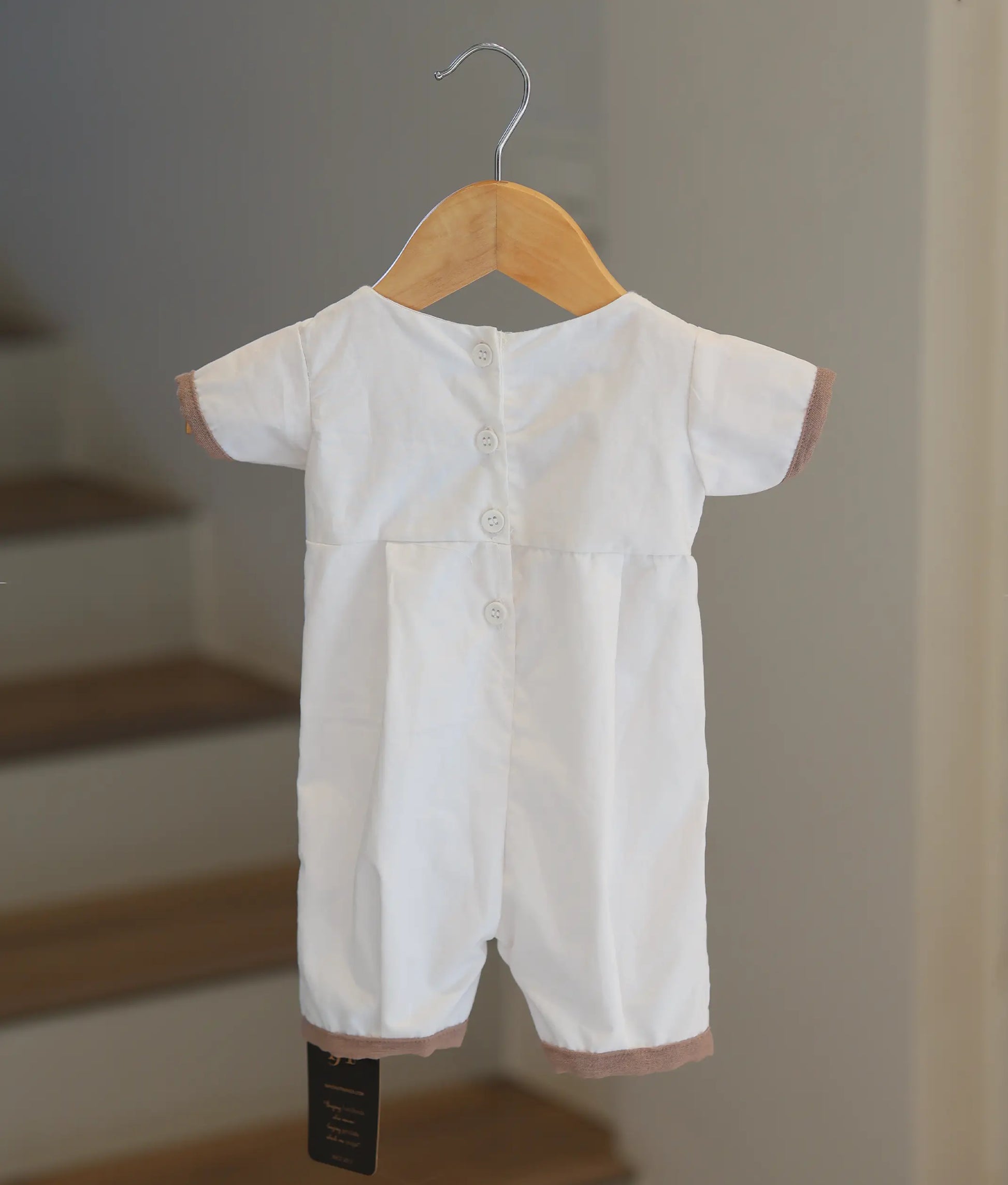 Back view of the white baptism romper showing the button closure.