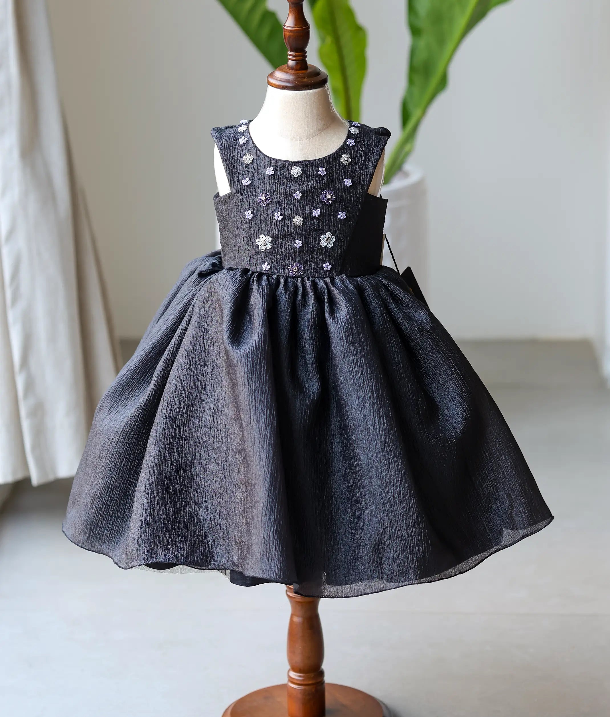 Front view of a black crush organza floral handworked birthday frock for baby girls featuring silver beadwork and a layered skirt