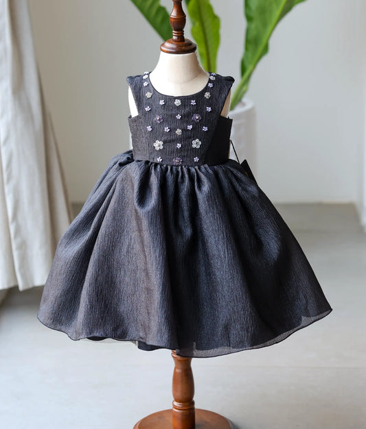 Front view of a black crush organza floral handworked birthday frock for baby girls featuring silver beadwork and a layered skirt
