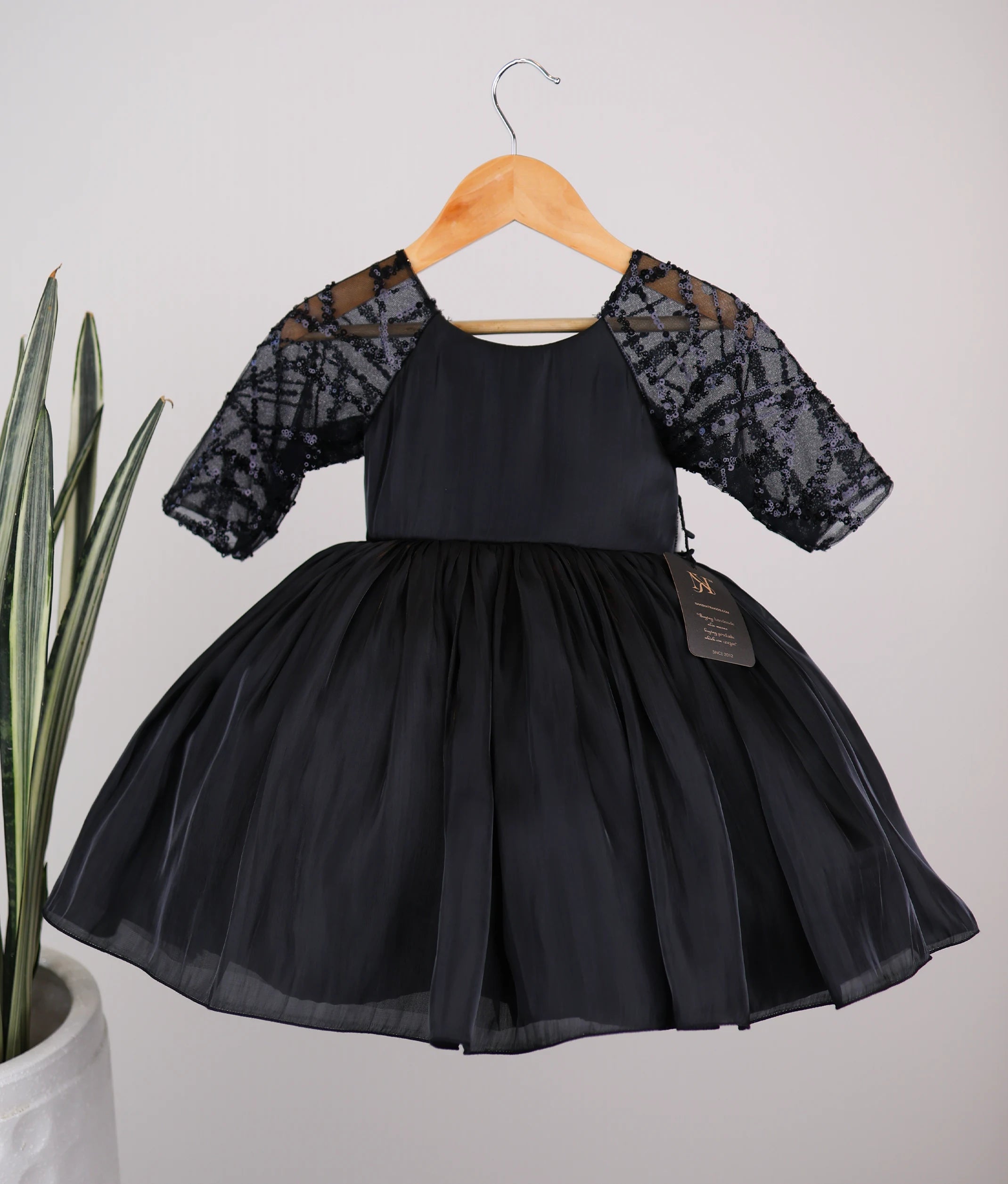 Front view of a black lacer organza flower girl dress for baby girls featuring sheer embellished medium sleeves and a flared skirt