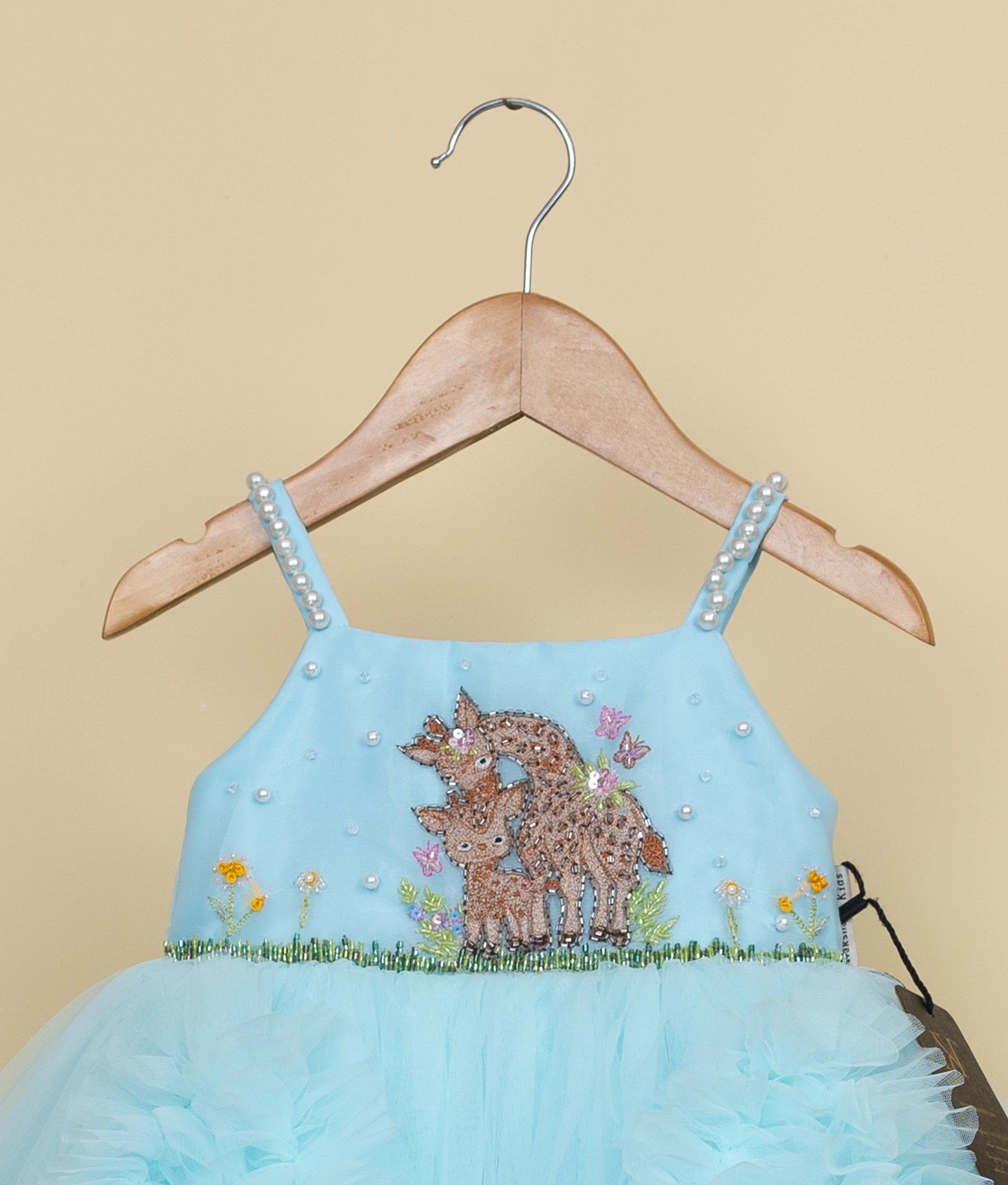 Close-up view of baby girl blue frock showing layered ruffles and tulle construction