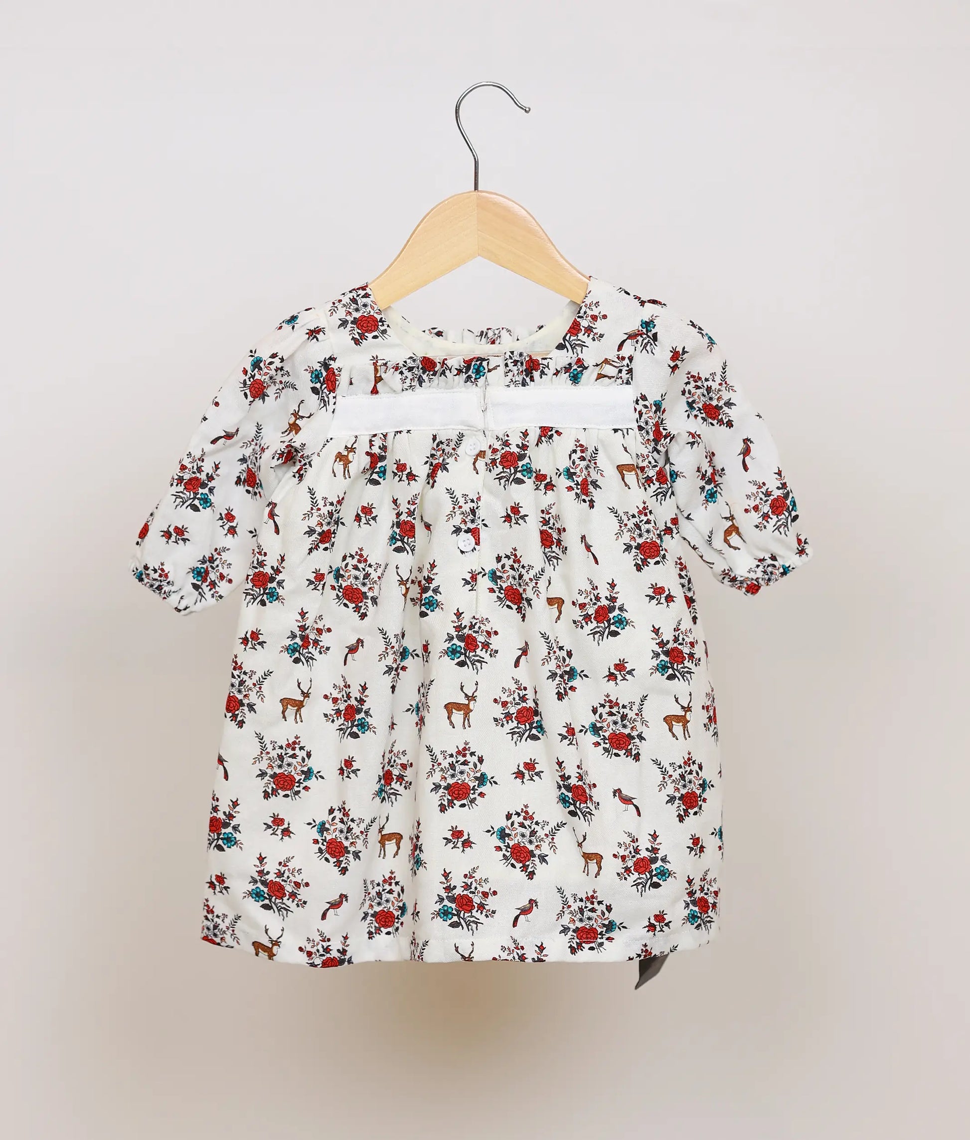 Three-quarter view of the White Floral Printed Cotton Frock, showing the gathered yoke and puff sleeves.